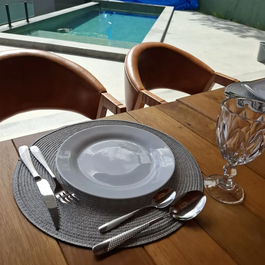 Mesa posta para o café da manhã na Pousada Reale, com taça e louça branca